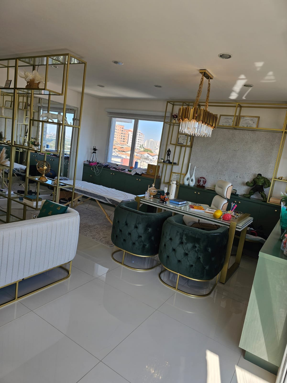 Mesa de avaliação com poltronas de veludo verde e lustre dourado